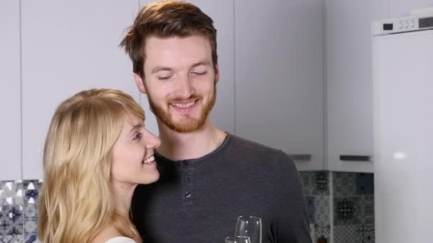 Jovem casal bebendo vinho tinto na cozinha em casa — Vídeo de Stock