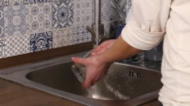 Adam ellerimden su dokunun mutfak içinde dan çalışan ile bulaşık yıkama