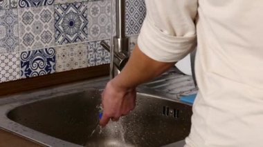 Adam ellerimden su dokunun mutfak içinde dan çalışan ile bulaşık yıkama