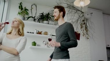 Genç çift evde mutfakta kırmızı şarap içme