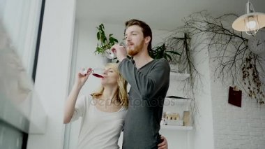 Genç çift evde mutfakta kırmızı şarap içme