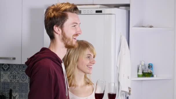 Genç çift evde mutfakta kırmızı şarap içme — Stok video