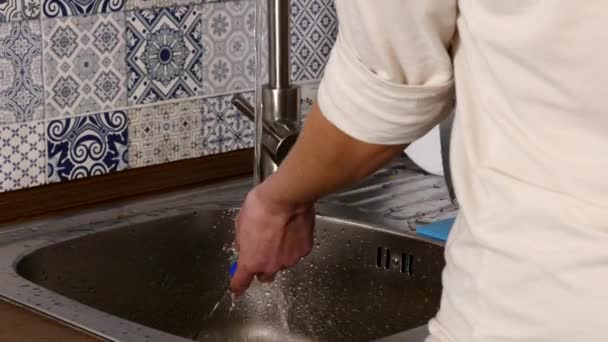 Lavare il piatto dalle mani dell'uomo con acqua corrente dal rubinetto in cucina — Video Stock