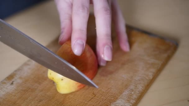 Řezací jablko na plátky. Příprava surovin na pečení jablečný koláč. Kuchař, krájení zdravé jablko na dřevěné prkno v kuchyni. Krájení na plátky oloupaných jablek — Stock video