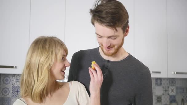 Casal feliz cozinhar na cozinha, enquanto o homem beijar sua namorada em casa — Vídeo de Stock
