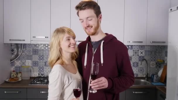 Junges Paar trinkt zu Hause in der Küche Rotwein — Stockvideo