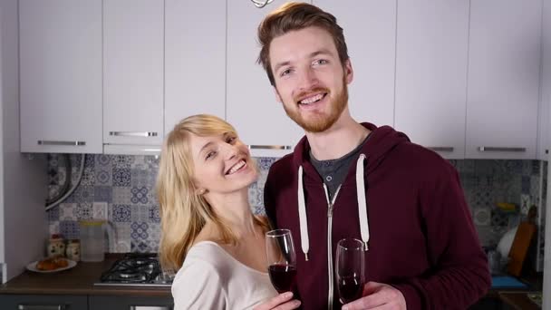 Šťastný pár zvyšování přípitek na fotoaparát stojící v kuchyni doma — Stock video