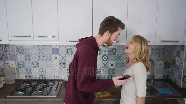 Молоді пара сварки на кухні. Чоловік і жінка кричати у відчай і сердито Gesticulate — стокове відео