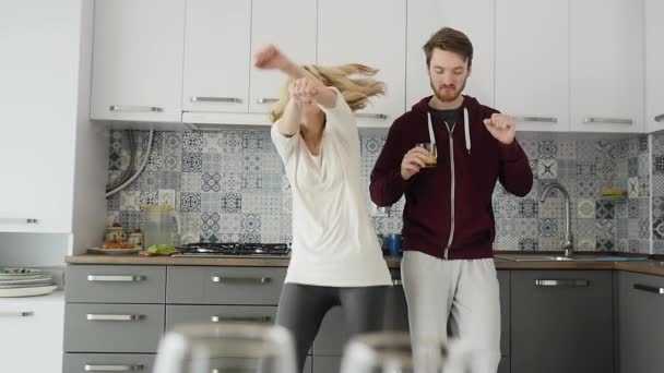 Ранок вдома щаслива молода пара щойно танцює, слухаючи музику на кухні — стокове відео
