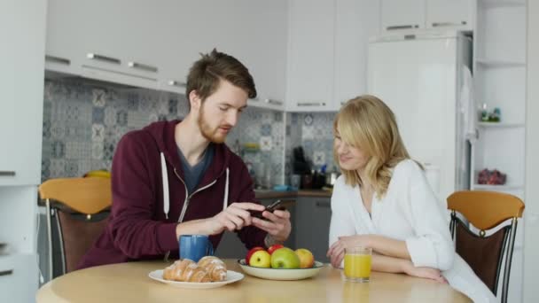 Attraktives Paar frühstückt zu Hause in der Küche — Stockvideo