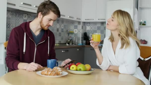 Attraktivt par som äter frukost tillsammans på hemma i köket — Stockvideo