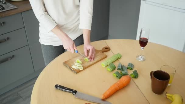 Jong meisje is een komkommer met een mes te snijden — Stockvideo