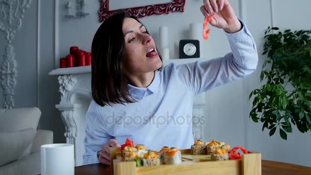 Menina alegre comendo um pedaço de sushi no restaurante — Vídeo de Stock