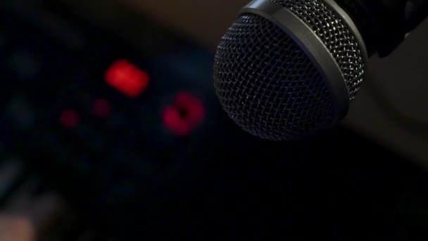 Microphone on a stand located in a music studio recording booth under low key light — Stock Video