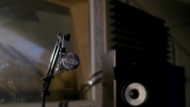 在位于关键弱光下的音乐工作室录制展位的架子上的麦克风 — 图库视频影像
