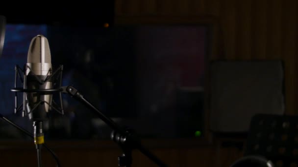 Micrófono en un soporte ubicado en una cabina de grabación de estudio de música bajo luz de baja luz — Vídeo de stock