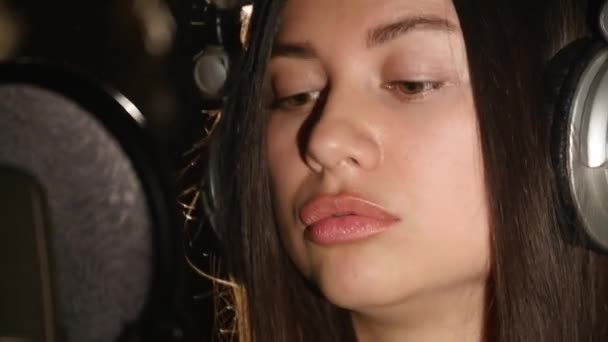 Női énekes-fejhallgató, mikrofon ellen — Stock videók
