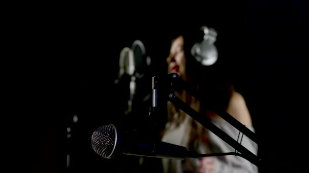 Όμορφο κορίτσι που τραγουδάει σε ένα στούντιο ηχογραφήσεων — Αρχείο Βίντεο