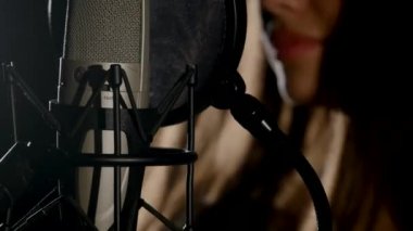 Mikrofon müzik stüdyo kayıt kulübesinde düşük anahtar ışık altında bulunan bir stand