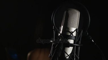 Mikrofon müzik stüdyo kayıt kulübesinde düşük anahtar ışık altında bulunan bir stand