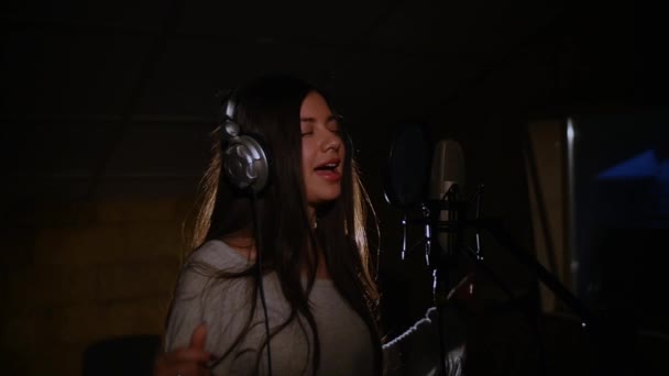 Beautiful girl sings in a recording studio — Stock Video
