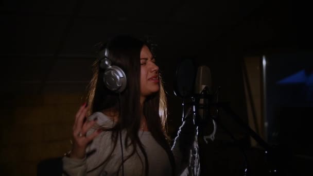 Beautiful girl sings in a recording studio — Stock Video