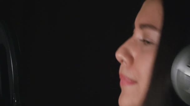 Mooi meisje zingt. Jonge zanger, zingen in een microfoon. Portret close up van de zanger — Stockvideo