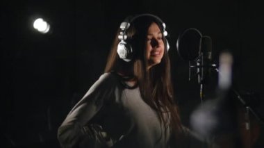 Ses kayıt stüdyosu. Kulaklıklar ve stüdyo mikrofon şarkı söyleyen kadın ile.