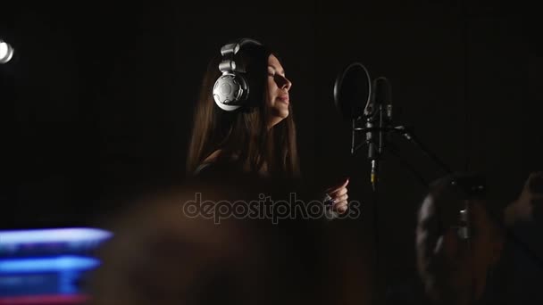 Mooi meisje zingt in de studio met de ondersteuningstechnicus — Stockvideo