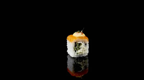 Sushi roll with salmon and caviar on black background rotating — Stock Photo, Image