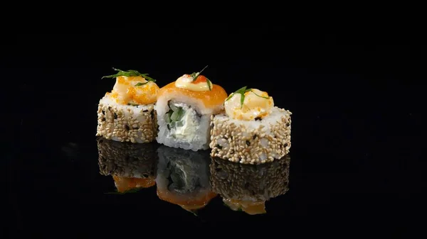 Tre olika sushi på svart bakgrund roterande — Stockfoto