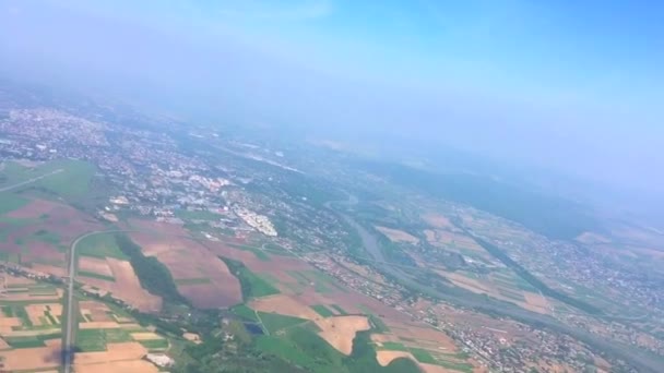 Vista sobre el paisaje de los campos y el río desde la ventana del avión volador — Vídeos de Stock