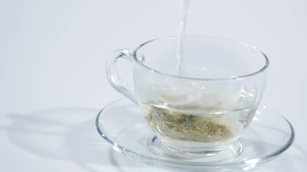 Sachet de thé dans une tasse en verre remplie d'eau chaude pour faire du thé. Mouvement lent 