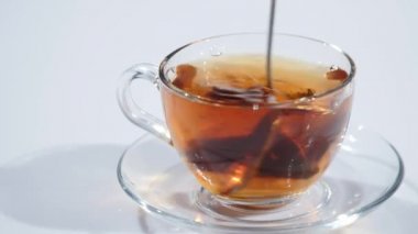 Çay cam Kupası'nda kaşıkla karıştırarak adam