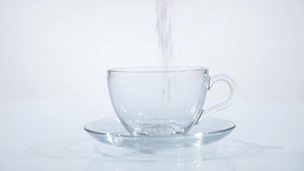 Las hojas de té están cayendo en taza transparente de vidrio. Movimiento lento — Vídeo de stock