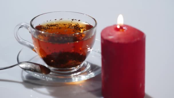 Filiżanka herbaty z oświetlenie czerwone świece na białym tle — Wideo stockowe