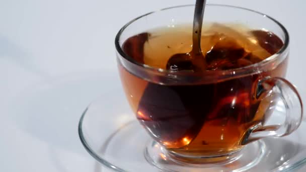 Homme brassant thé avec cuillère dans une tasse en verre — Video
