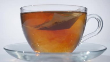 Çay cam Kupası'nda kaşıkla karıştırarak adam
