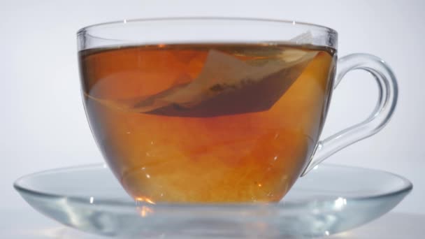 Homme brassant thé avec cuillère dans une tasse en verre 