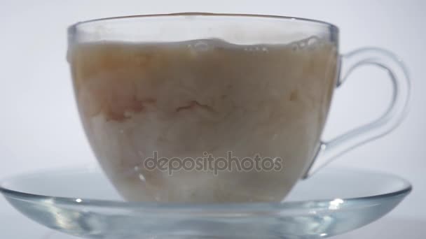 Добавление молока к черному чаю в стеклянную кружку, закрыть — стоковое видео