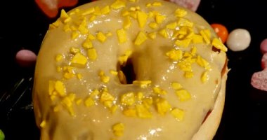 siyah arka plan üzerine izole normal hız ile dönen sprinkles ile sırlı tatlı çörek 4 k görüntüleri