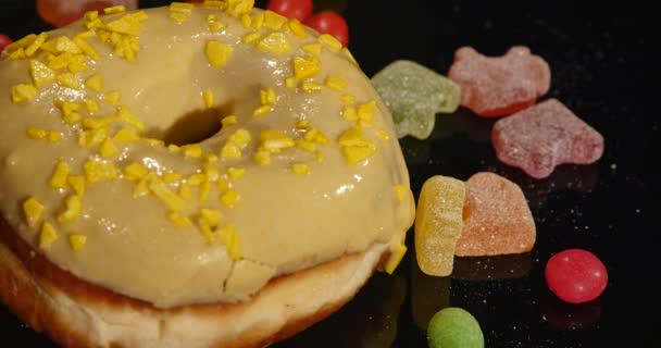 Filmagem em 4K de donut doce envidraçado com polvilhas, girando com velocidade normal, isolado em fundo preto — Vídeo de Stock