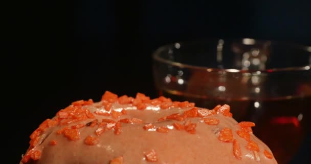 Красочные пончики и чашка чая на черном столе — стоковое видео
