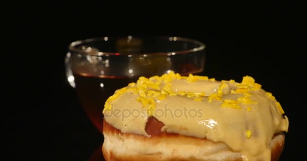 Taza de té y rosquillas sobre fondo negro — Vídeo de stock