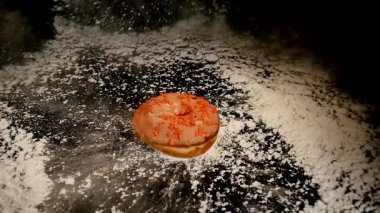 Çörek pudra şekeri ile siyah bir masa üzerine düşüyor