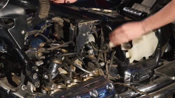 Jovem sério reparando sua moto na garagem — Vídeo de Stock