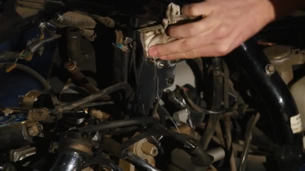 Jovem sério reparando sua moto na garagem — Vídeo de Stock