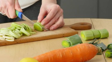 Genç çift akşam yemeği hazırlıyor. Kız kesme besindir. Adam ona sarılıyor