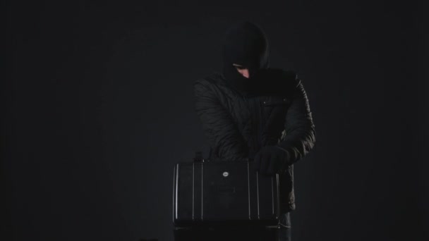Ein maskierter Mann hält eine Waffe in der Hand. Terrorismuskonzept — Stockvideo