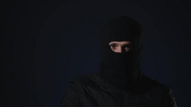Maskeli bir adam elinde bir silah alır. Terörizm kavramı